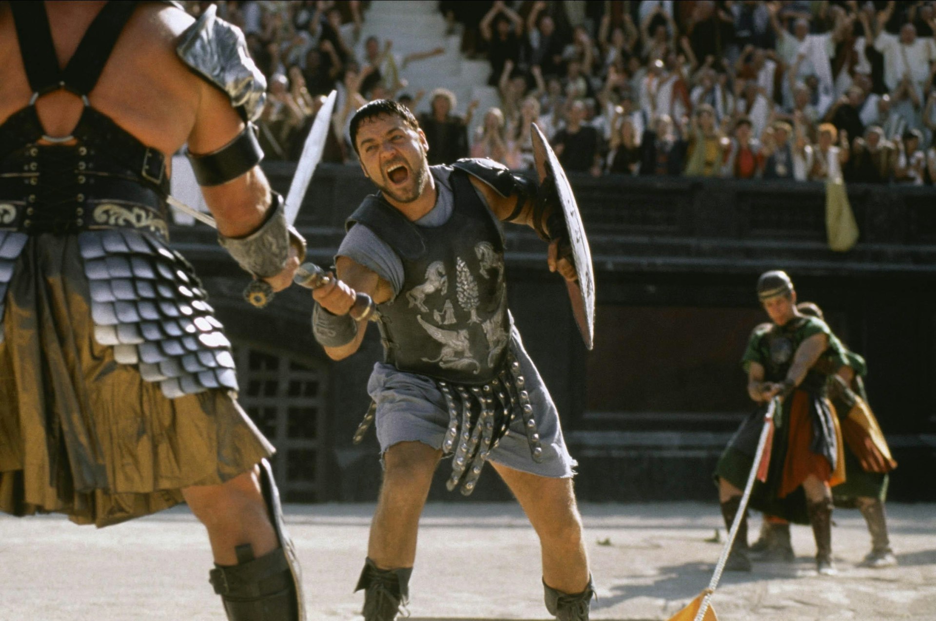 A man dressed as a Roman gladiator fights another man in a large arena