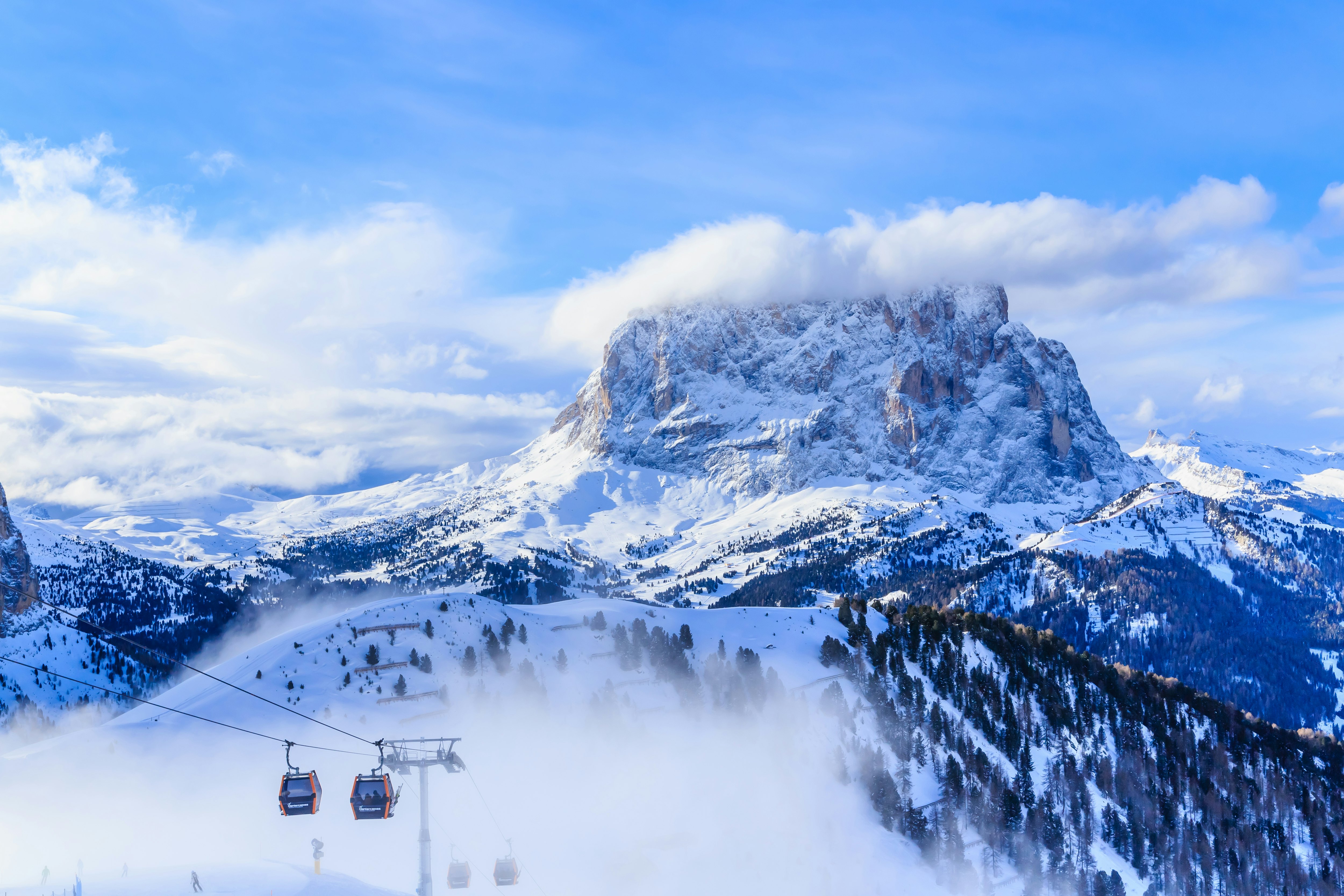 Two ski-lifts and people on the slopes at Selva in Val Gardena